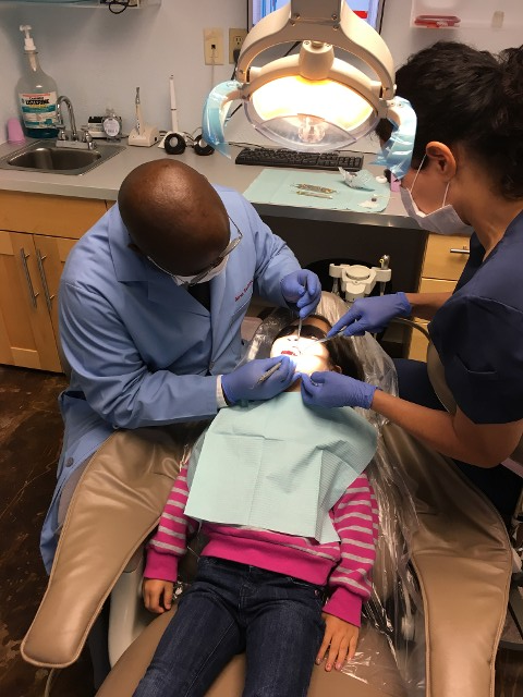 Dentist Cleaning Child's Teeth